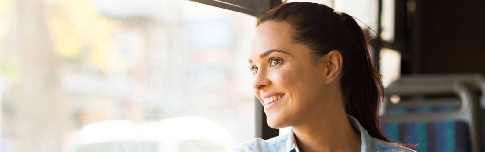 A woman smiles while riding the EC Rider Bus